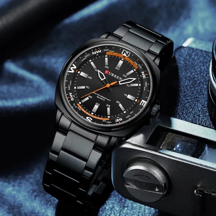 Black wristwatch with detailed face on a textured blue background