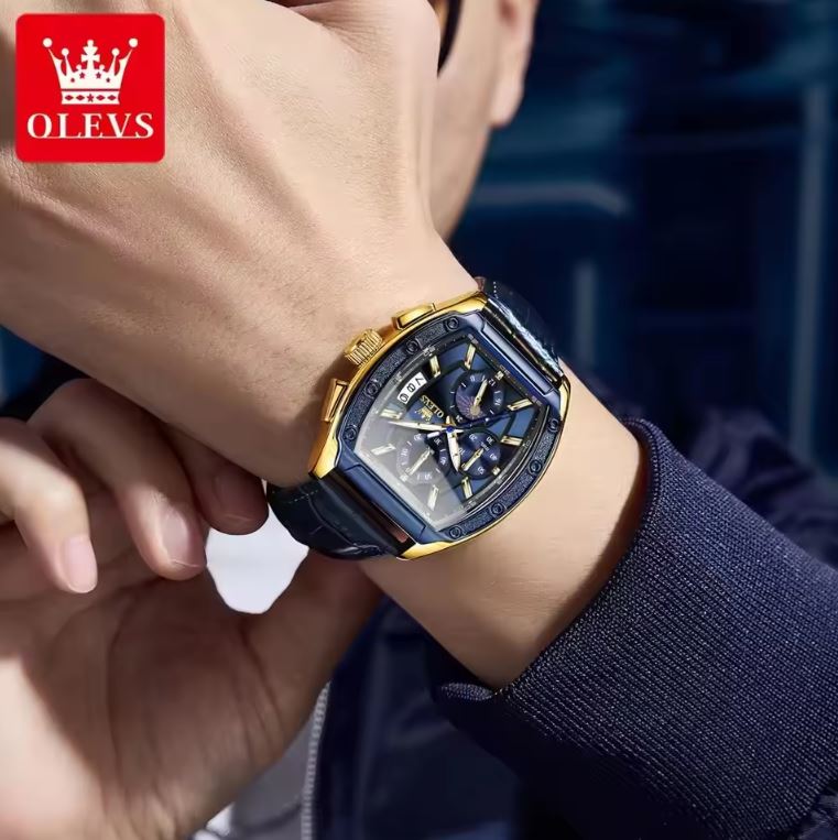 Person wearing a gold and blue watch with OLEVS logo in the corner