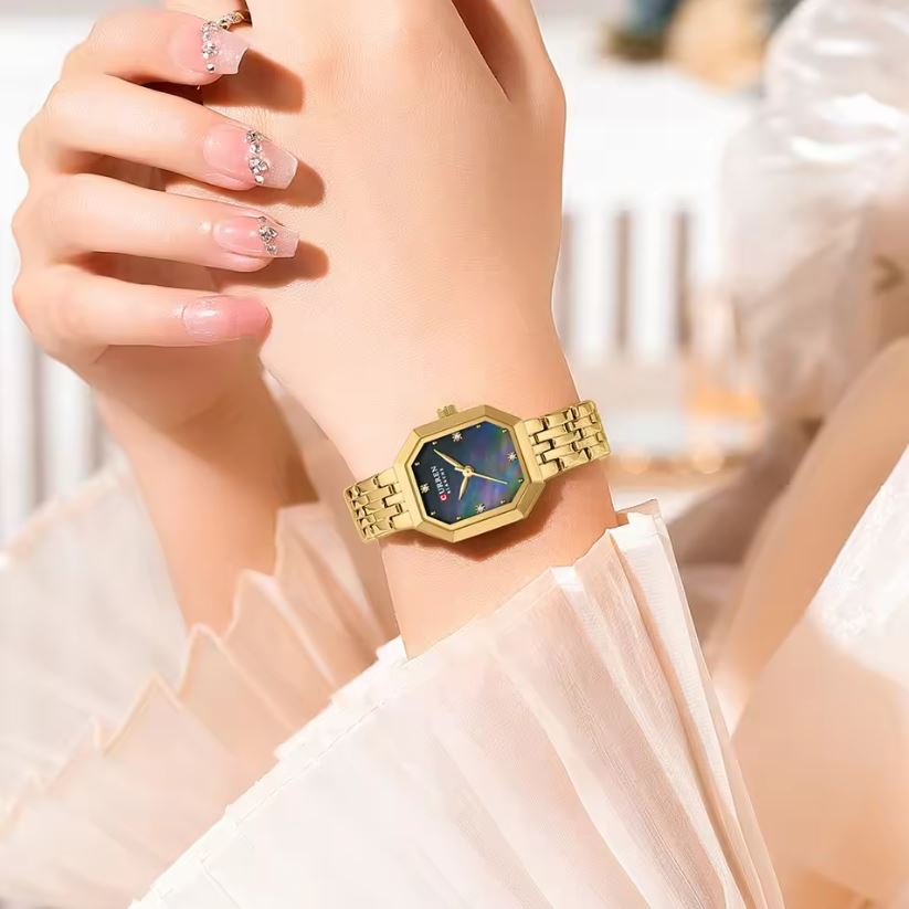 Gold watch with a colorful face on a wrist, blurred background