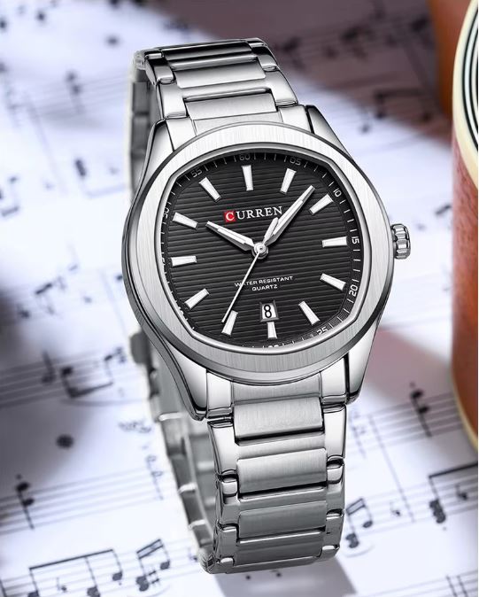Silver wristwatch with black dial on a sheet of music