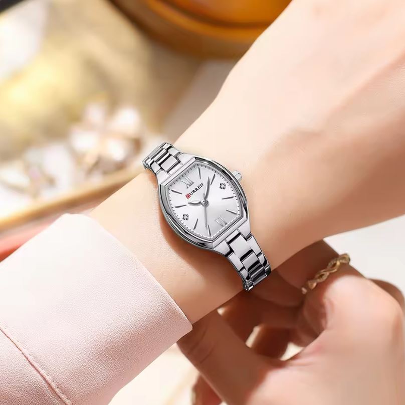 Silver wristwatch on a person's wrist with a blurred background