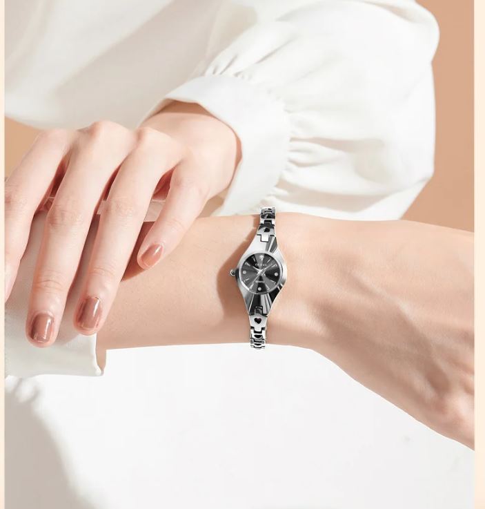 Silver bracelet with a watch face on a wrist against a white background
