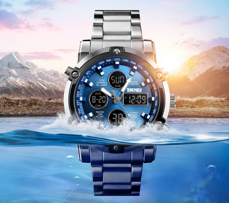 Digital watch with blue face and silver strap on water with mountain background
