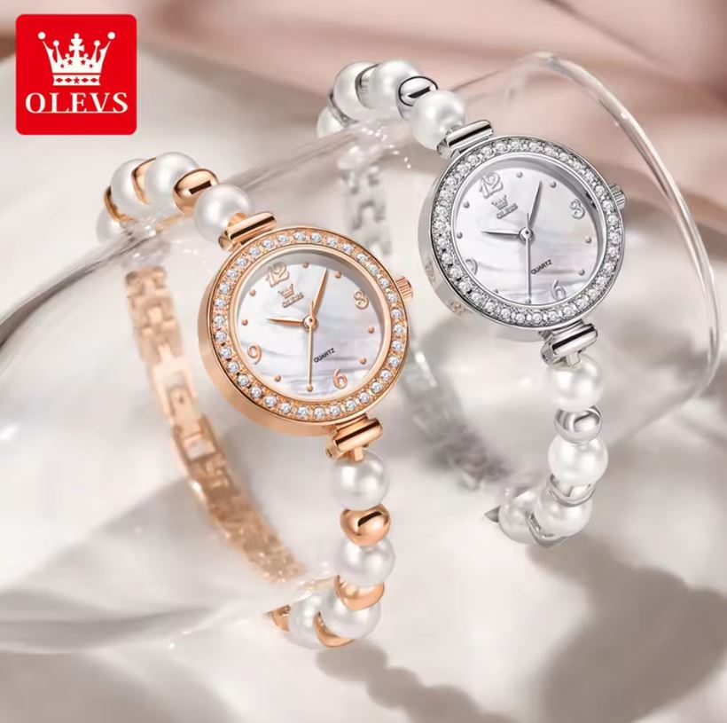 Two pearl-branded watches with pearl straps on a soft background