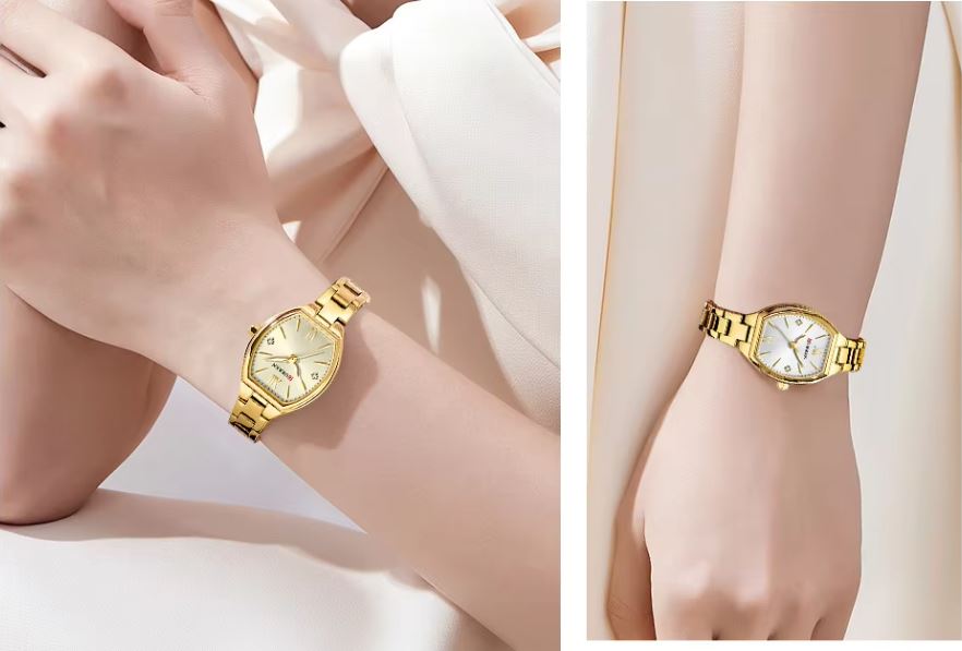 Gold wristwatch on a person's wrist against a light background