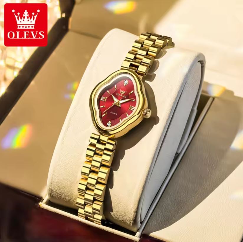Gold wristwatch with red face on a display stand, branded 'OLEVS'.