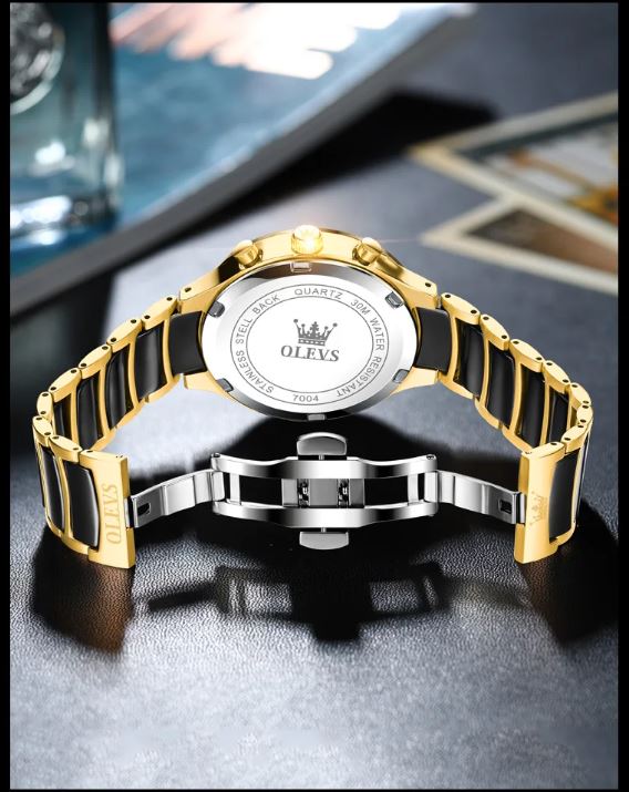 Gold and silver watch with black accents on a dark surface