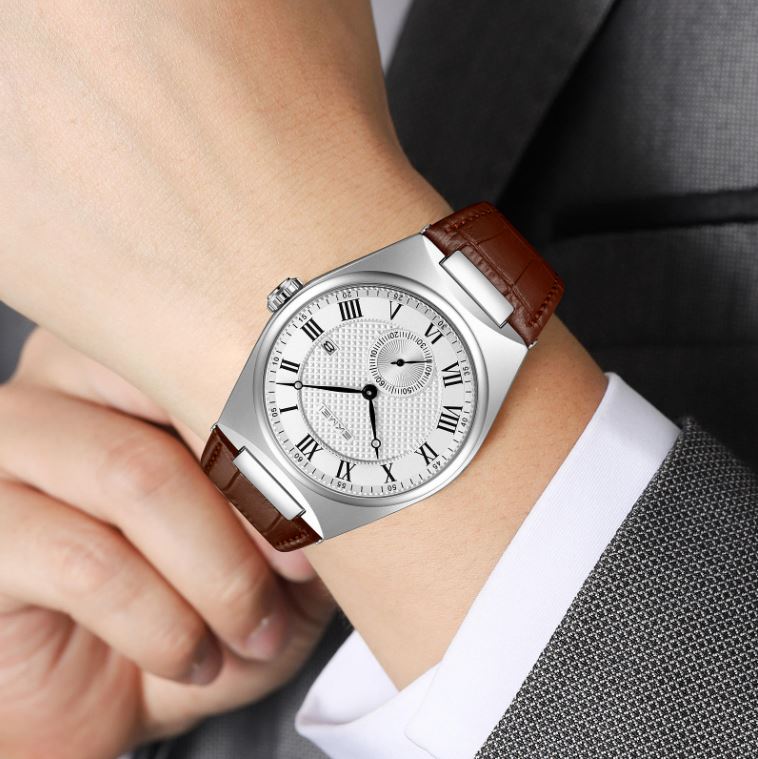 Silver wristwatch with brown leather strap worn on a wrist, close-up view.