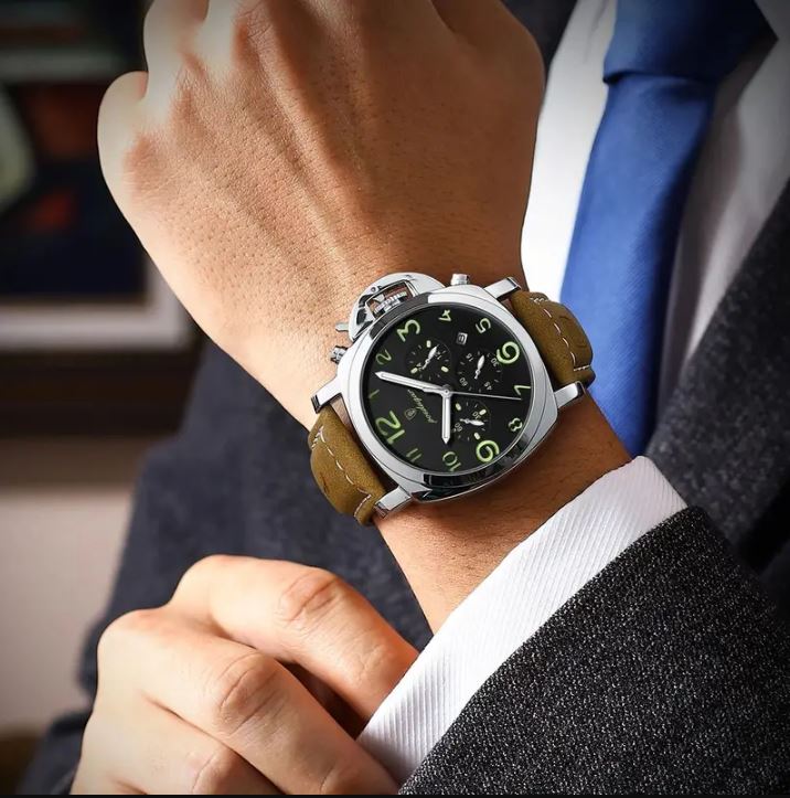 Close-up of a person wearing a stylish wristwatch with a brown leather strap.