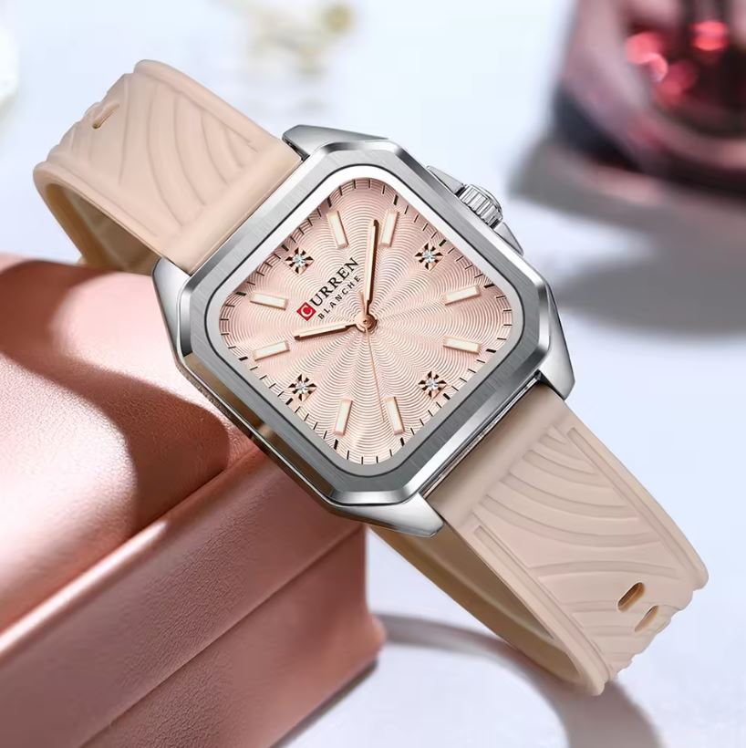 Wristwatch with beige strap and pink dial on a white background