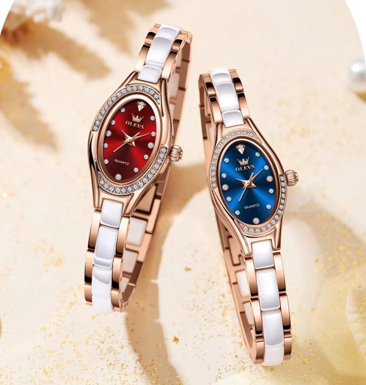 Two elegant wrist watches with red and blue dials on a textured beige background
