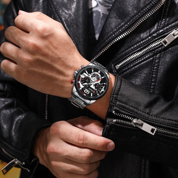 Person wearing a black leather jacket with a watch on their wrist