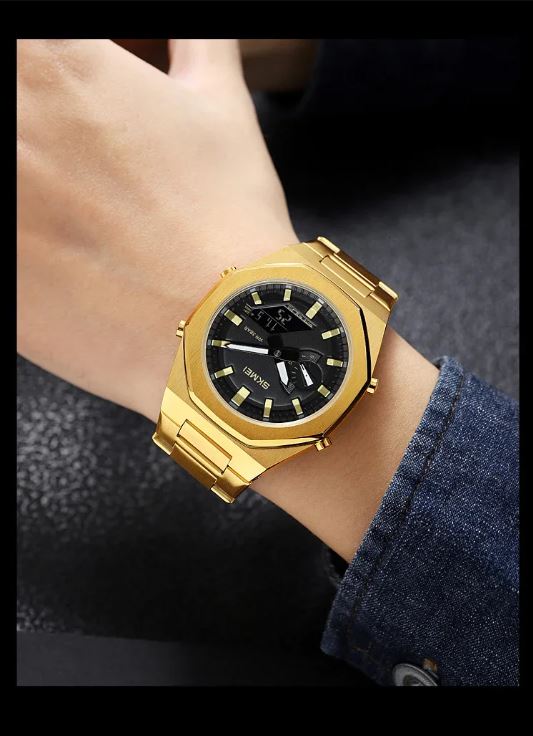 Gold wristwatch with a black face on a person's wrist, wearing a dark blue shirt.