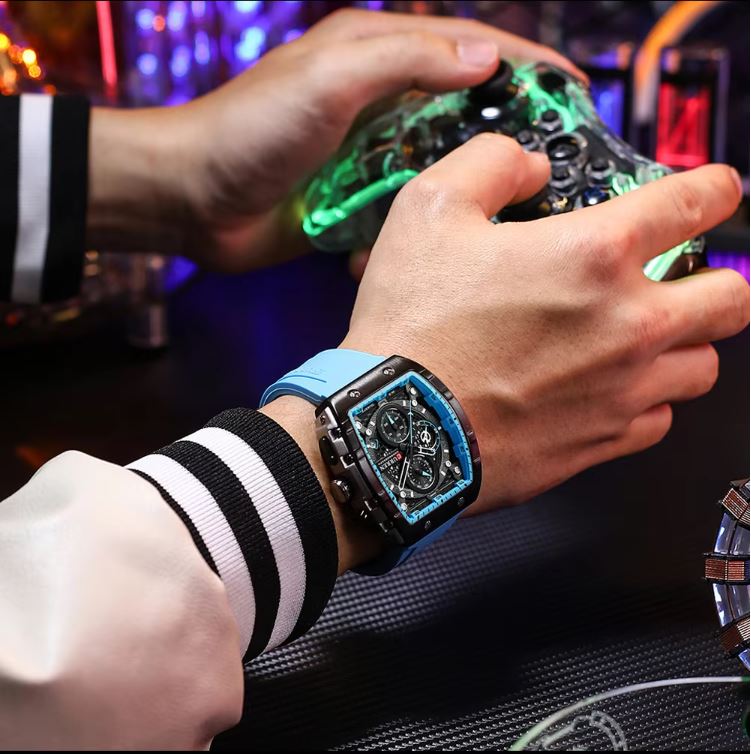 Person playing a video game with a futuristic controller, wearing a watch with a blue strap.