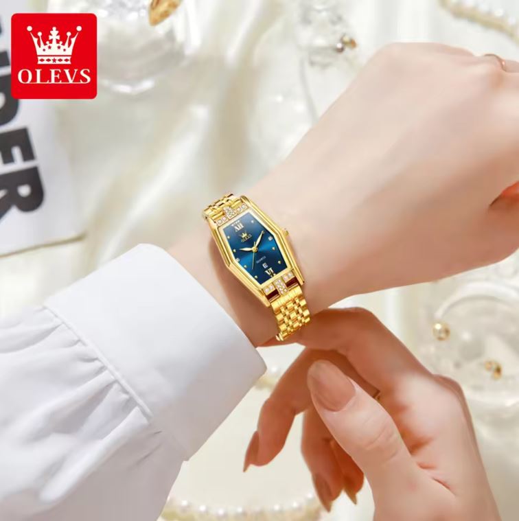Gold wristwatch on a person's wrist with a blurred background and OLEVS logo.