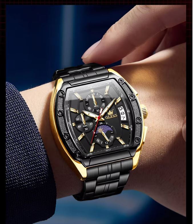 Luxury watch with black and gold design on a wrist against a dark background