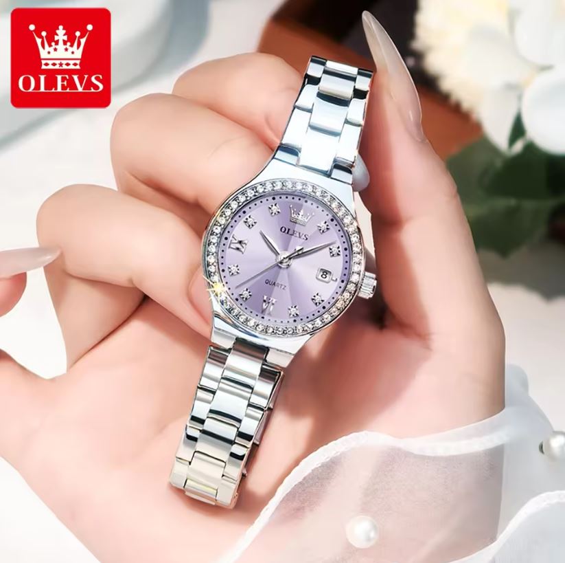 Silver watch with purple face held in a hand, brand 'OLEVS' visible