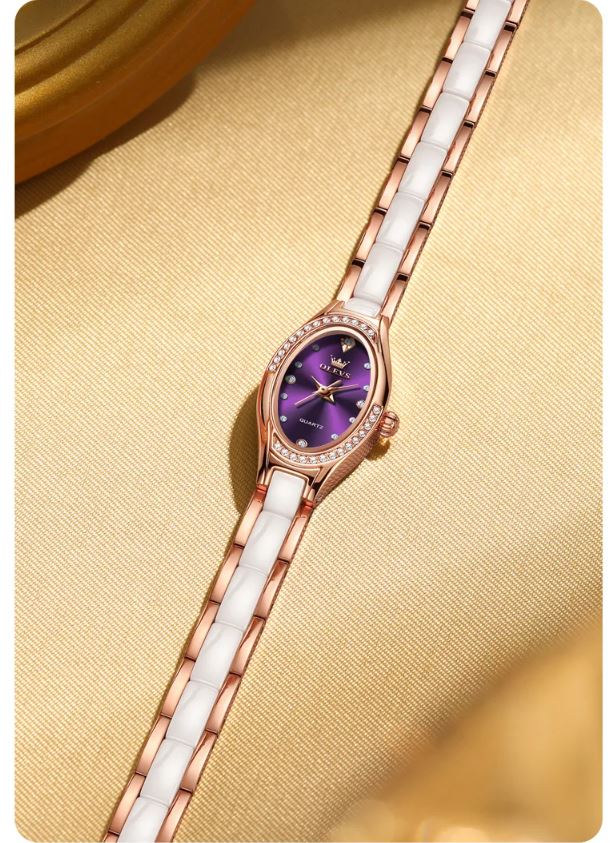 Luxury watch with purple face and white strap on a beige background