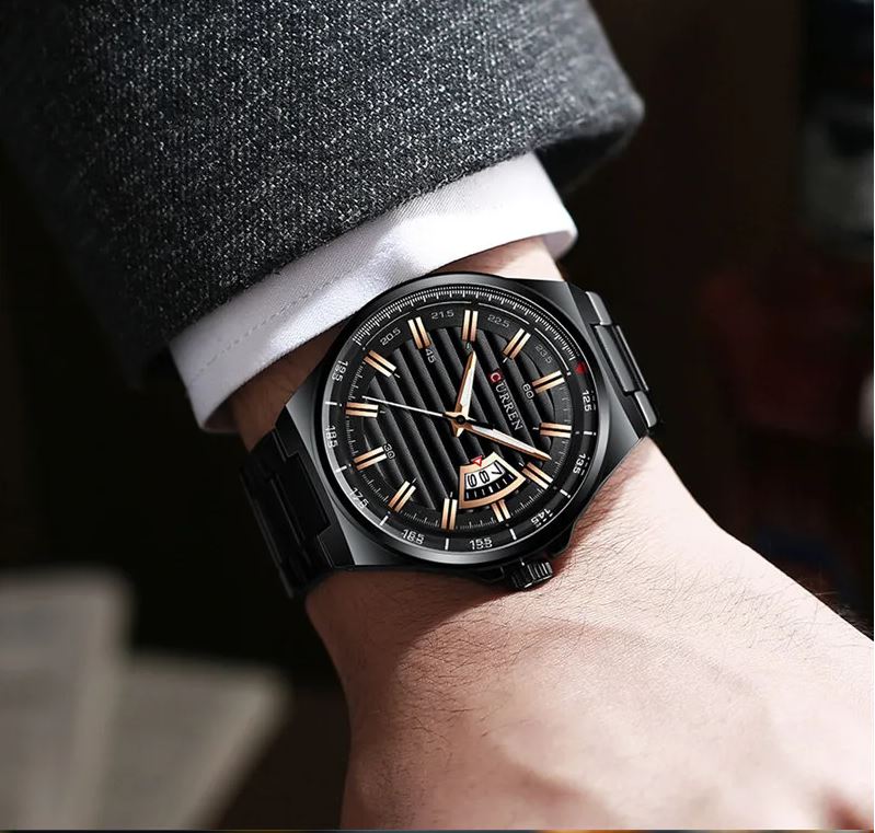 Luxury watch on a person's wrist with a dark strap and black dial.