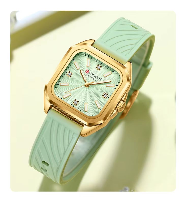 Green watch with gold accents on a light yellow background