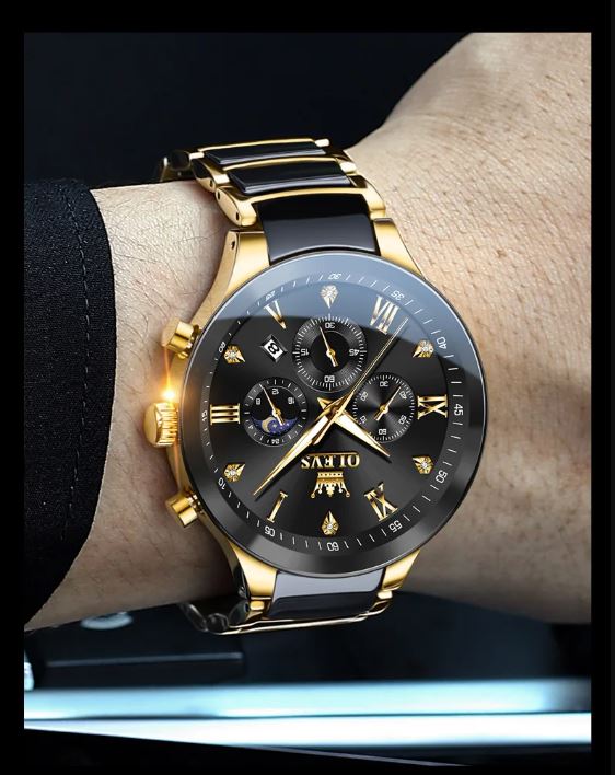 Gold and black watch on a wrist with a dark background