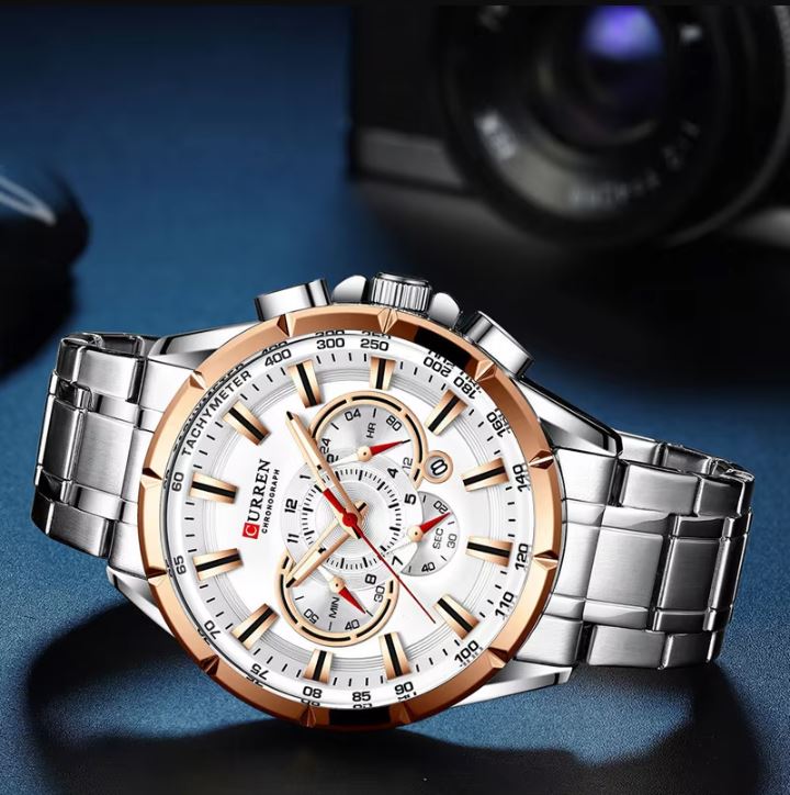 Silver and rose gold watch with white face on a dark blue background