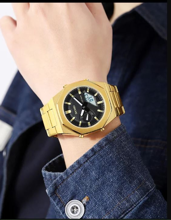 Gold wristwatch on a person's wrist with a blue denim jacket