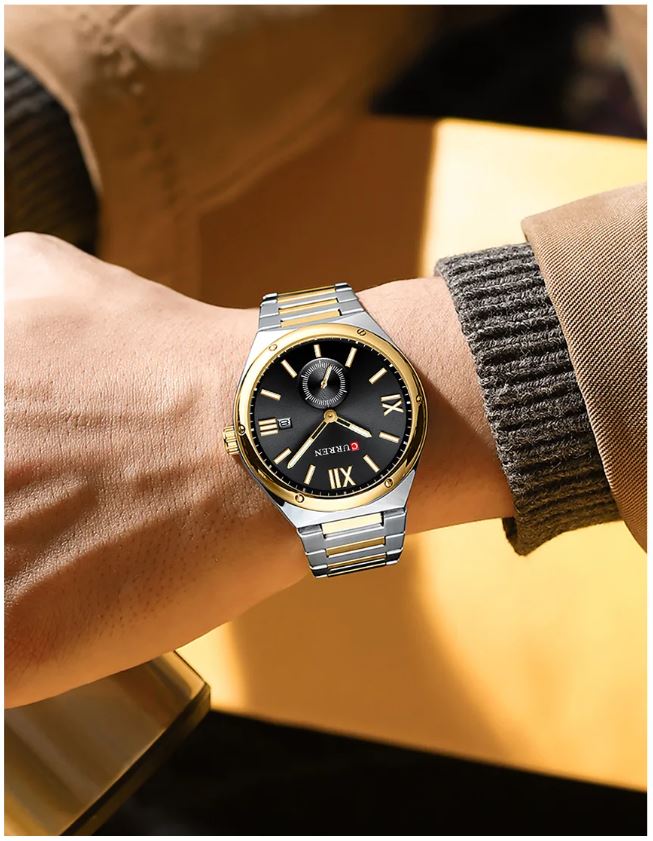 Silver and gold watch on a wrist with a blurred background
