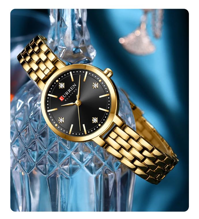 Gold wristwatch with black dial on a decorative background