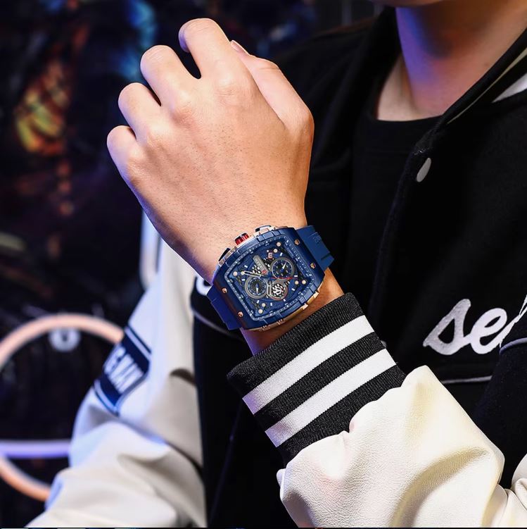 Person wearing a blue wristwatch with a dark background