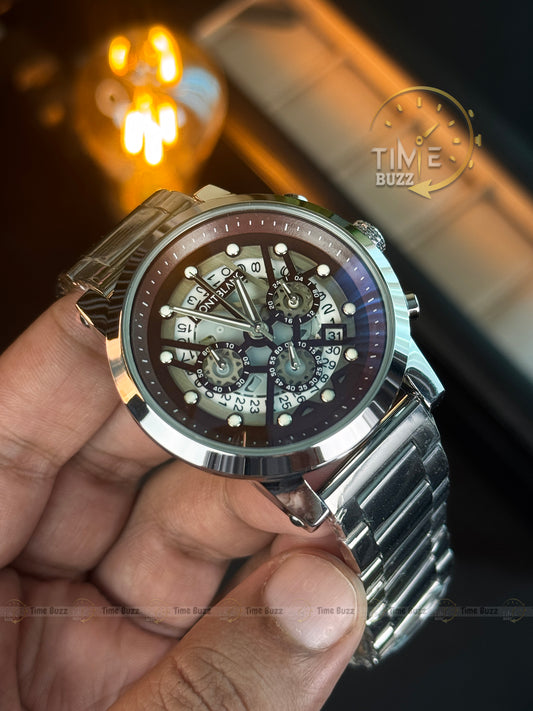 Close-up of a person holding a silver wristwatch with a visible brand logo.