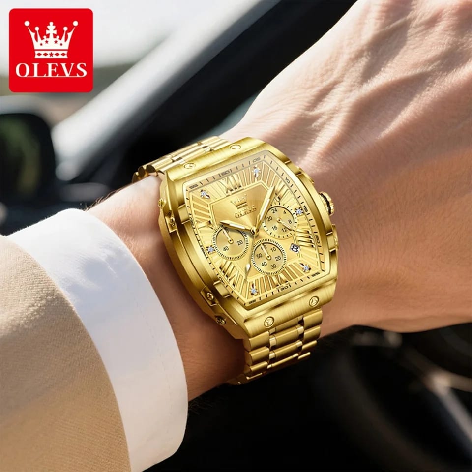 Gold wristwatch on a person's wrist with OLEVS logo in the corner.