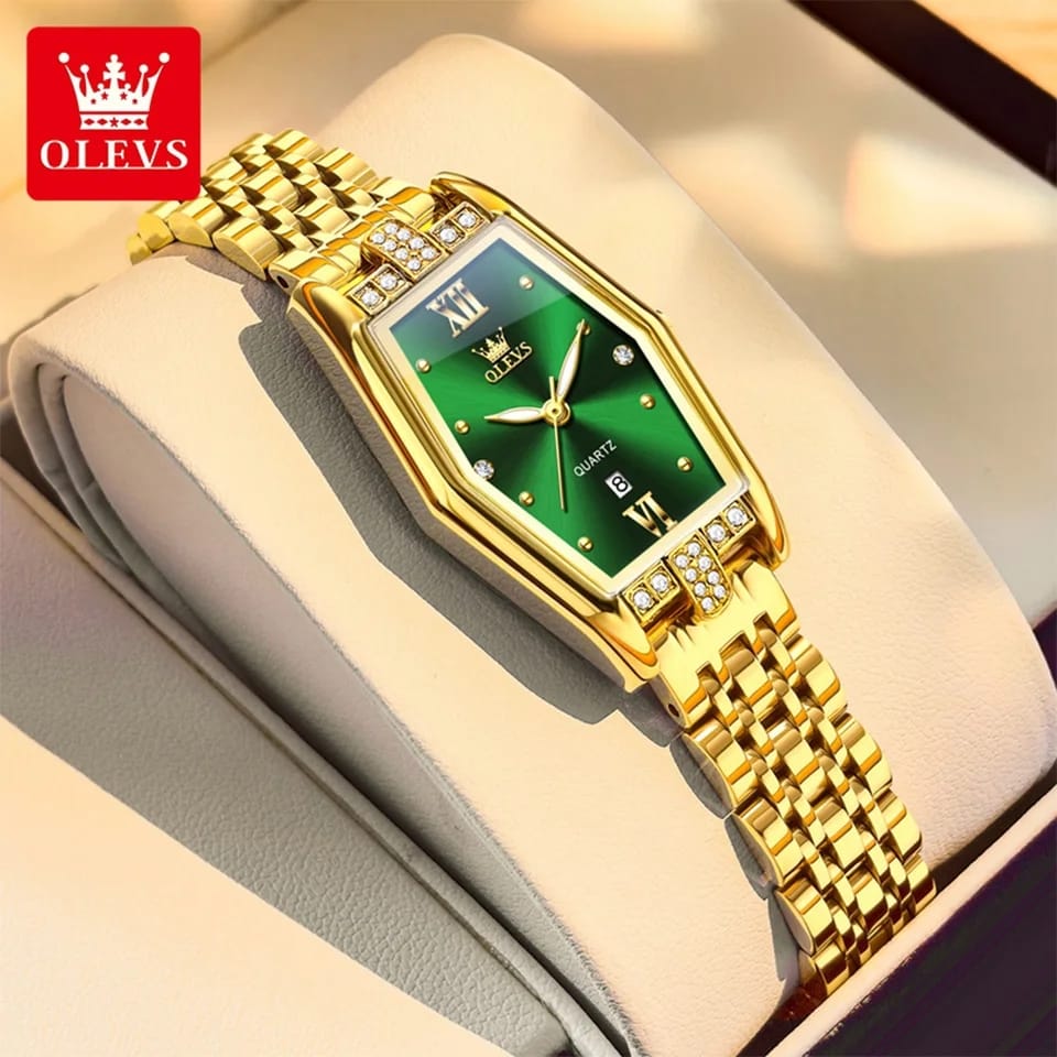 Gold wristwatch with green face on a soft surface, brand 'OLEVS' visible