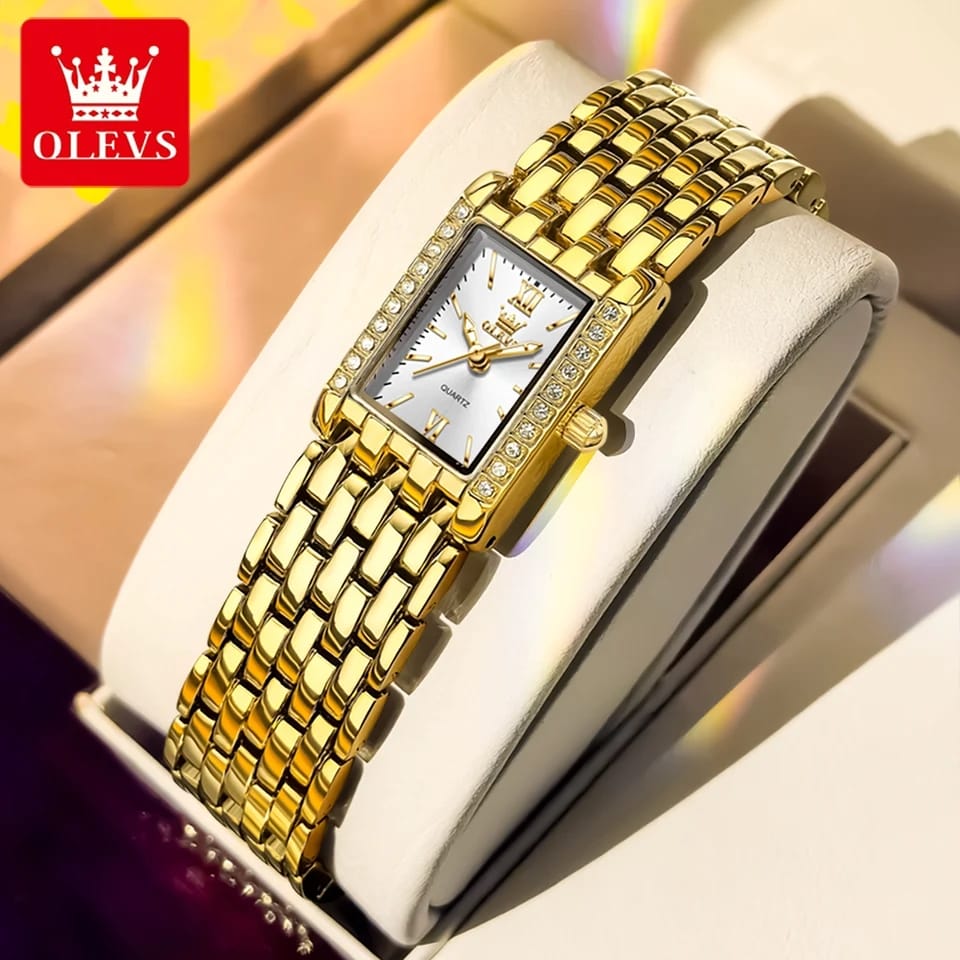 Gold wristwatch with a white face in a box, branded OLEVS.
