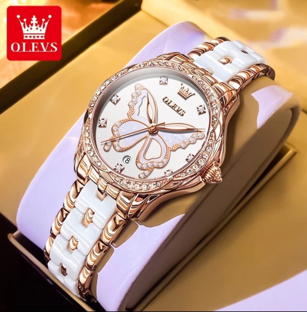 Luxury watch with white strap and rose gold casing on a gold surface, featuring the OLEVS brand.