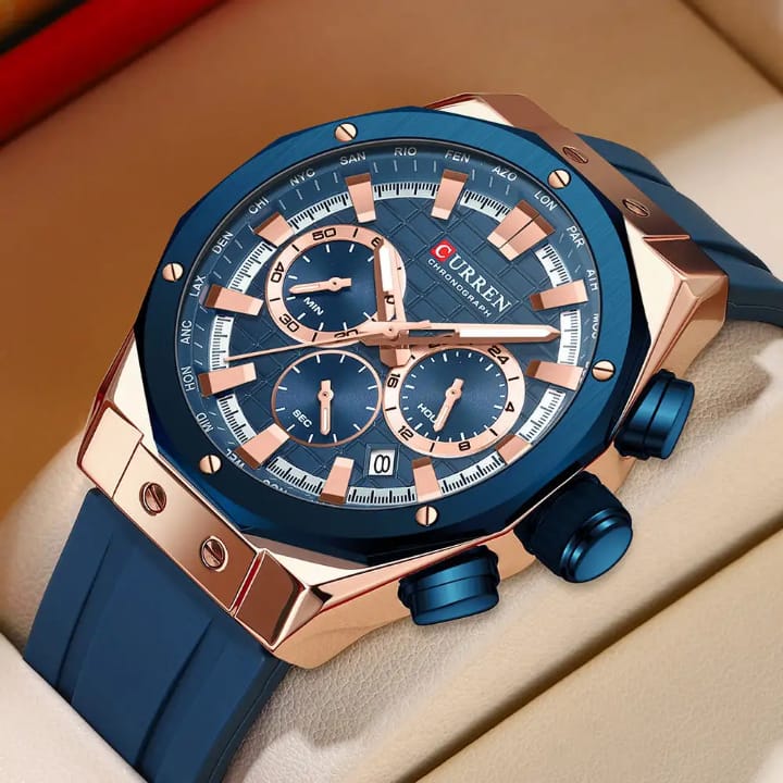 Blue and rose gold watch with 'Curren' branding on a beige surface