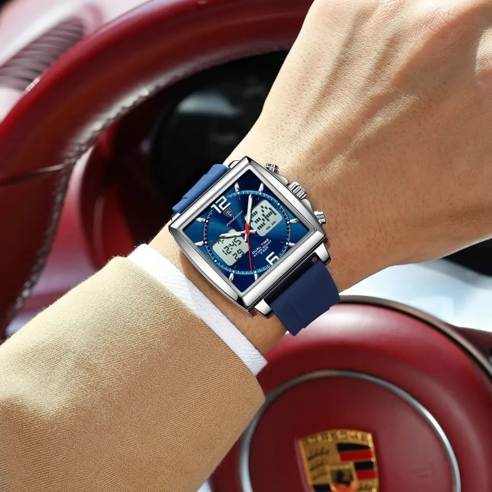 Person wearing a blue watch with a Porsche logo in the background