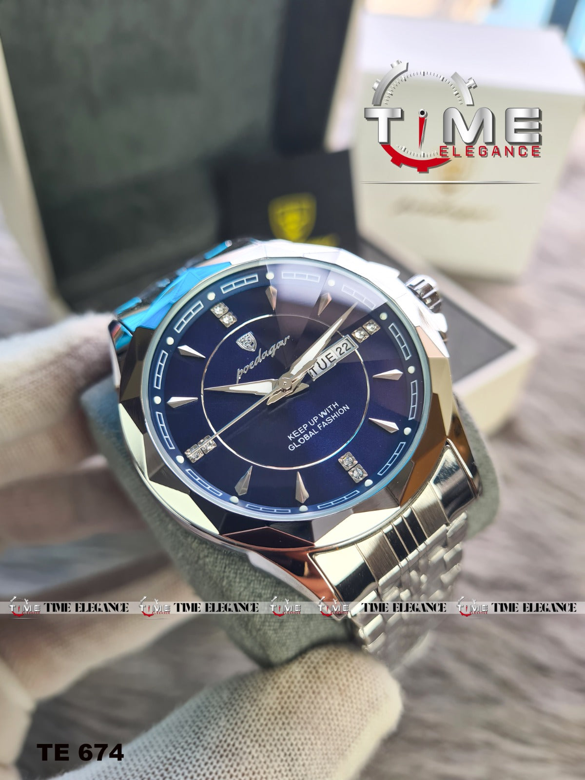 Luxury watch with blue dial and silver case on a blurred background