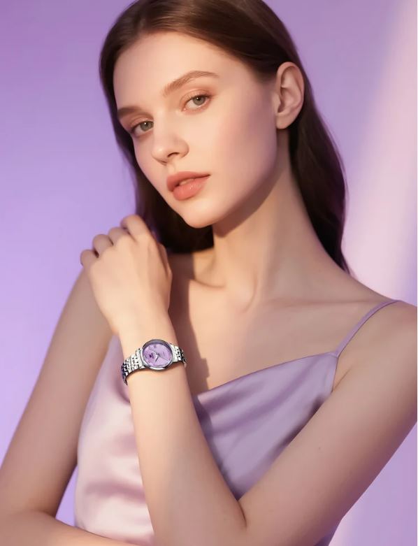 Woman wearing a purple watch against a pink background