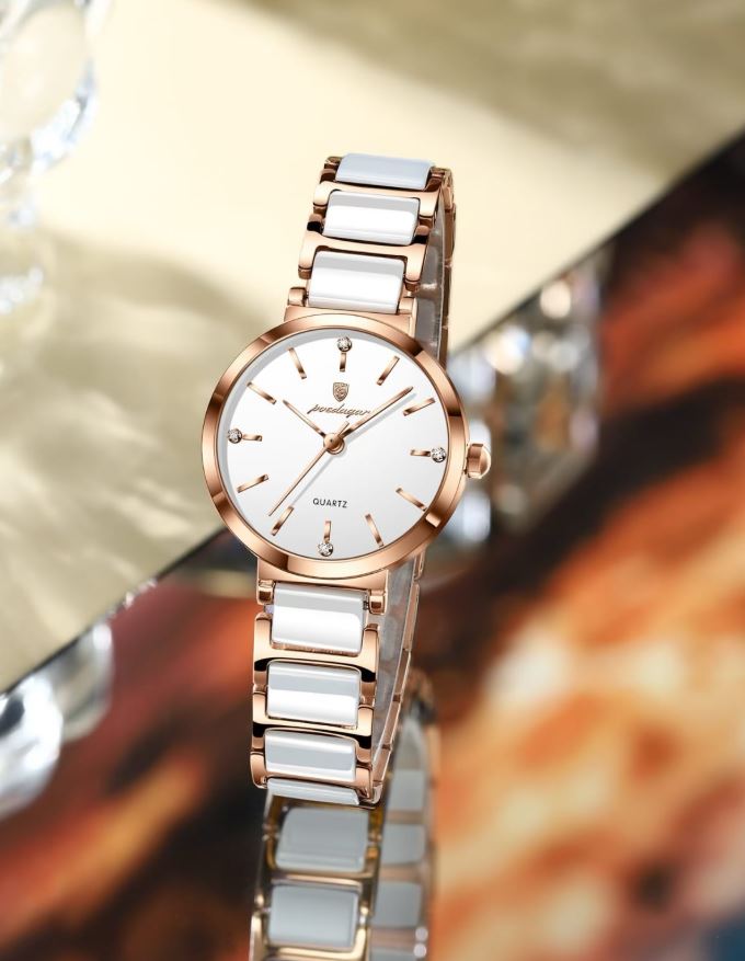 Rose gold and white ceramic watch on a blurred background