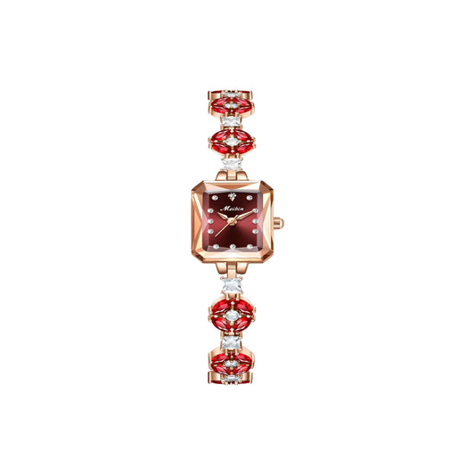 Watch with red gemstone accents on a white background